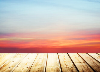 Wooden table on sky background and sunset light	
