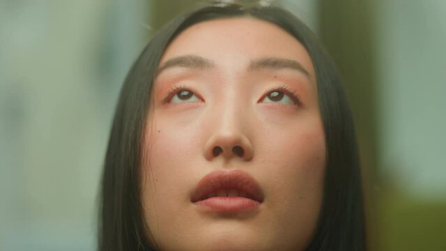 Close up Asian woman face young chinese korean faithful dreaming girl looking up calm peaceful emotion sad japanese female lady student girlfriend think future hope pray faith dream look contemplate