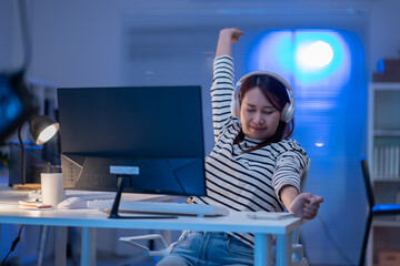 Asian woman working overtime in office.Asian woman arms stretched and working at office.young...