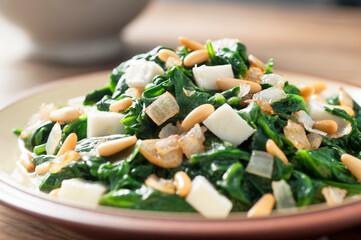 spinach with fresh cheese and pine nuts