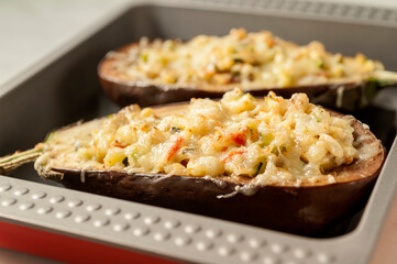 Two halves of aubergines stuffed with vegetables and baked gratin