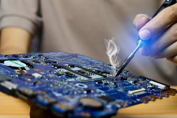 Technician concept repairing computer motherboard, soldering circuits