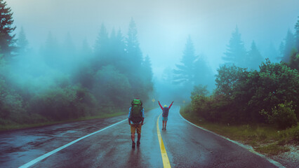 Lover asian man and asian women travel nature. Walk on the road route. traveling nature happily. Amid the mist rainy.