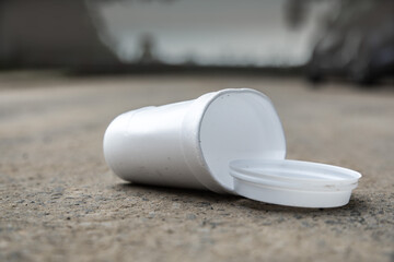 close up of a waste plastic coffee cup lying in the street