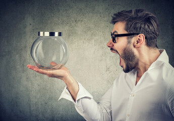 Angry man screaming at a closed glass jar 