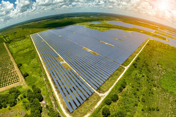 Aerial view of big sustainable electric power plant with many rows of solar photovoltaic panels for...