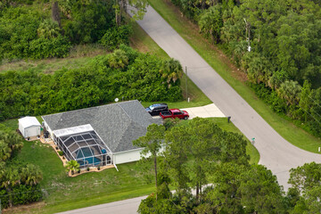 Aerial view of typical contemporary american private house with roof top covered with asphalt shingles and green lawn on yard