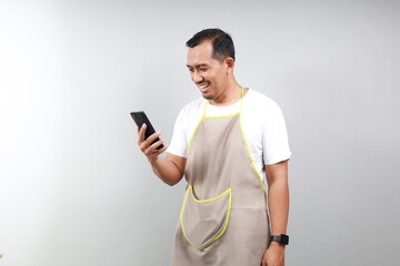 Asian man barista bartender barman employee in brown apron white t-shirt work in coffee shop using...