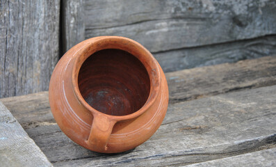 clay old pot on a wooden old table. background blur. clay dishes