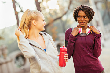 Two female joggers chatting in a park