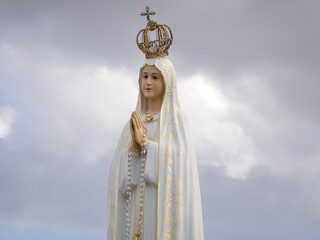 Imagem da Virgem Maria numa procissão solene, adornada num andor numa festividade estival