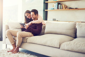 Smile, couple and hug on sofa with tablet for social media, news or streaming together to relax. Digital technology, man and woman in living room for online shopping or reading blog on app in home