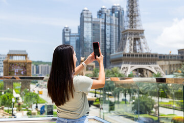 Tourist woman use mobile phone to take photo in Macau city