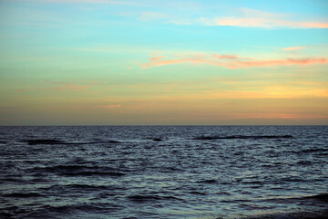 Obraz premium Dramatic red ocean waves at sunset with soft evening sea dark water