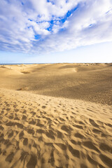 The dunes of Maspalomas in the south of the island Grand Canary with several unidentifiable visitors strolling around. Maspalomas, Grand Canary, Spain.