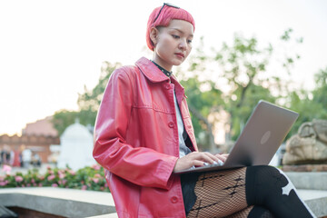 Gen z girl leather fashion with punk Asian woman working remotely on laptop digital nomad in...