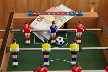 Close-up macro shot of a table football game and money on the football field, sports betting, money...