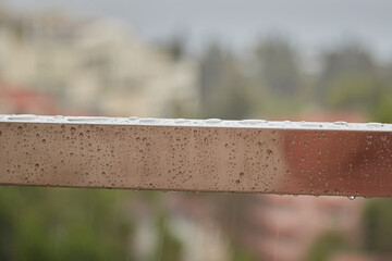 Raindrops on an iron handrail, caution slippery railings, wet railings, water on metal, close-up