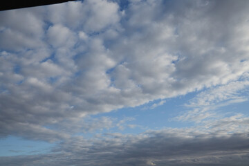 Fototapeta premium Fluffy white and gray clouds on blue sky background. Copy space