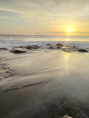 Yellow-orange sunset and sunrise on the ocean shore, Bali island. Epic sunrise, sandy beach. Landscape of Indonesia