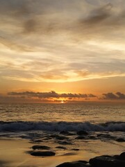 Yellow-orange sunset and sunrise on the ocean shore, Bali island. Epic sunrise, sandy beach. Landscape of Indonesia