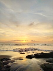 Yellow-orange sunset and sunrise on the ocean shore, Bali island. Epic sunrise, sandy beach. Landscape of Indonesia