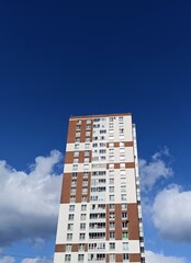 Modern apartment building on a background of blue sky with white clouds.