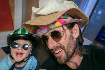Smiling father and son having fun with hats.
