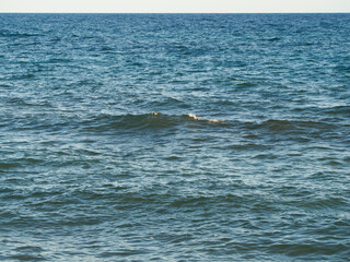 Photo on the surface of crashed waves on the beach of the coast. Tropical surf on the beach. waves on the golden sand of the beach. Fantastic sea view with calm sea water waves and sunlight