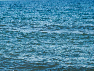 Obraz premium Photo on the surface of crashed waves on the beach of the coast. Tropical surf on the beach. waves on the golden sand of the beach. Fantastic sea view with calm sea water waves and sunlight