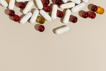 Top view of red and white pill capsule on beige isolated background. Place for your design. The concept of pharmacy, health care.