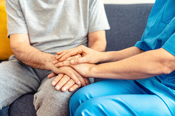 Female doctor nurse holding hand of senior man patient having disease health problem - Empathy,...