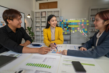 Three people are sitting around a table with papers and a calculator. They are discussing something important. Scene is serious and focused