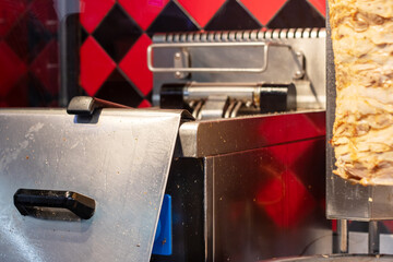 Closeup of a red machine cooking food with a magenta bumper and metal exterior