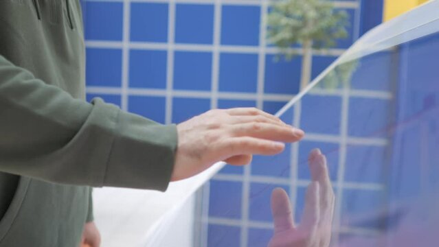 Woman using interactive touchscreen display scrolling and touching. Entertainment and technology concept.