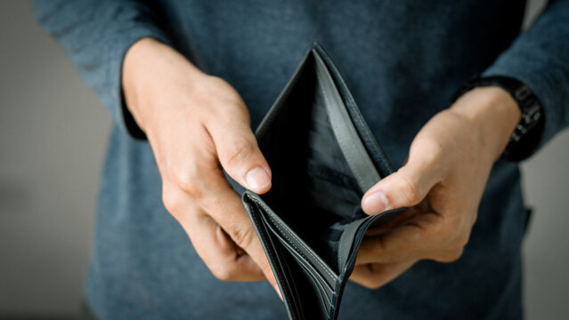 Bankrupt man, empty wallet (no money) in the hands of a bankrupt man due to economic downturn, no credit, crisis, high cost of living in the city. No money in wallet and bankruptcy