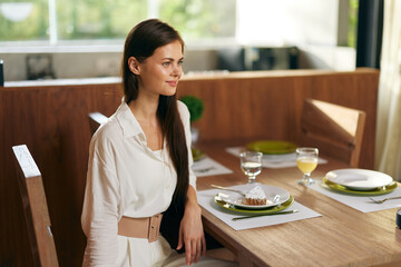 Happy Woman Enjoying Romantic Dinner at Elegant Dining Table with Delicious Homemade Cake and Wine