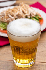 グラスにいれたビールと棒棒鶏（バンバンジー）