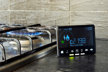 Gas and electricity meter in British Kitchen in front go lit Gas cooker