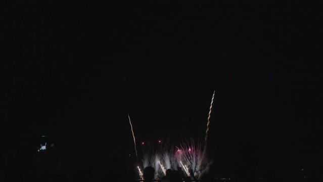 Glowing fireworks exploding over the sea in Pattaya, creating a dazzling display of light and color on a joyful night of celebration.