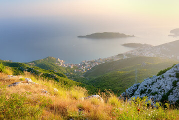 Aerial view of Budva Riviera from Fort Kosmach at sunset. Old fortress ruins is located in mountains near Budva in Montenegro. Amazing panoramic landscape of Adriatic coast with Saint Nikolay Island