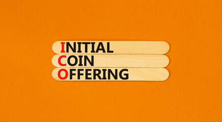 ICO initial coin offering symbol. Concept words ICO initial coin offering on beautiful wooden stick. Beautiful orange background. Business ICO initial coin offering concept. Copy space.