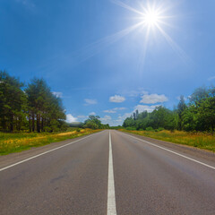 long asphat road under a sparkle sun, summer transportation scene
