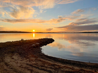 Sandy bay-shaped beach in lake Saimaa during sunset