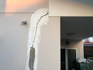 Cracked building concrete wall at the outside reveals clear fissures due to soil subsidence. This 8...