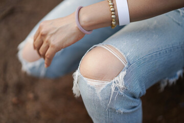 Jeans torn or ripped jeans Asian female leg, focus and close up to the knee.
