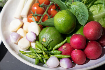 Ingredients of Spicy salad are prepared on black granite top table with various vegetable and herb.