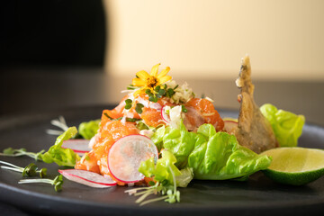 Spicy Raw Salmon Salad Thai food style decorated with Crispy fried fish skin and Yellow Flower on...