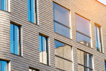 Obraz premium Clinker brick wall facade of residential building with multiple windows. Clinker bricks for exterior walls in residential and commercial structures. Brickwork in architectural design