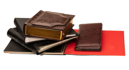 Stack of photo albums, business card holder and red spiral bound brochure isolated on a transparent background